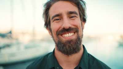 Close-up portrait of a smiling man with a beard on the embankmen